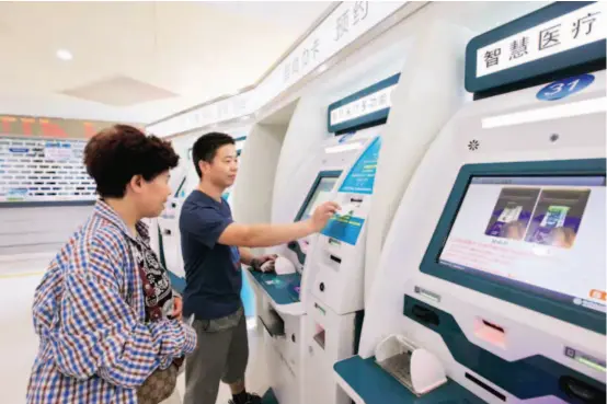  ??  ?? July 3, 2017: Residents make payments with their social security cards at a self-service terminal in a hospital in Ningbo City, Zhejiang Province. VCG