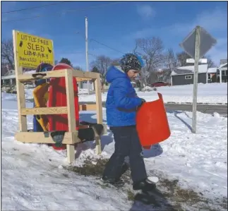  ??  ?? Austin Cooper, 10, of Kansas City, Mo., borrows a sled from the Little Free Sled Library.