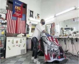  ??  ?? Una barbería en La Habana decorada con banderas de EEUU.