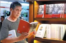  ?? ZHU XINGXIN / CHINA DAILY ?? A customer reads Xi Jinping’s Seven Years as an Educated Youth in Wangfujing Bookstore Beijing, on Sunday.