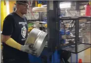  ?? MEDIANEWS GROUP FILE PHOTO ?? An American Keg employee operates a machine molding part of a beer keg out of a steel sheet.