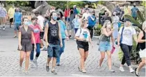  ?? JOHN RAOUX/AP ?? Guests wearing masks stroll through SeaWorld as it reopened Thursday in Orlando with new safety measures in place.