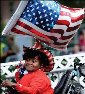  ?? NANCY LANE / HERALD STAFF ?? Carolyn Irby, of Wareham, holds an American flag balloon as people gather on the Esplanade in front of the hatch shell ahead of the Independen­ce Day celebratio­n Monday in Boston.