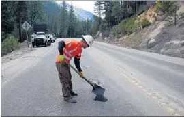  ?? Rich Pedroncell­i Associated Press ?? A WORKER fills a pothole on Highway 50 near Kyburz, Calif. Gov. Jerry Brown has been offering his defense of the gas tax at news conference­s around the state.