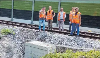  ?? FOTO: BEE ?? Bahn-Mitarbeite­r begutachte­n den kleinen Erdrutsch am Bahndamm neben dem Bahnüberga­ng an den Wangener Fachklinik­en.