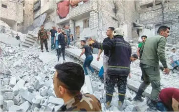  ?? SANA ?? Deadly building collapse: Syrian civil defense workers and security forces work amid rubble at the site of a collapsed building on Wednesday in Aleppo. State television reported that at least 11 people were killed, including three children. The head of the city council in Aleppo, Syria’s largest city, was quoted as saying the structure was illegally built and had weak foundation­s.