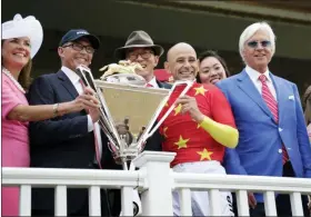  ?? FRANK FRANKLIN II - THE ASSOCIATED PRESS ?? FILE - In this June 9, 2018, file photo, jockey Mike Smith, second from right, trainer Bob Baffert, right, and owners Kenny Trout, second from left, and Teo Ah Khing pose with the Triple Crown trophy after race horse Justify won the 150th running of the Belmont Stakes horse race, at Belmont Park in Elmont, N.Y.