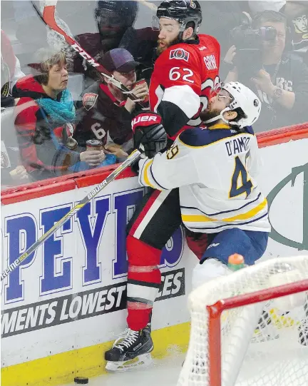  ?? JUSTIN TANG/THE CANADIAN PRESS ?? The Senators’ Eric Gryba is held against the boards by Buffalo’s Jerry D’Amigo during Friday’s game in Ottawa.