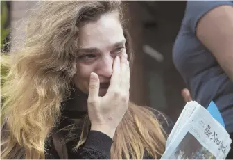  ?? aP PHOTO ?? SAD DAY: New York Daily News staff reporter Chelsia Rose Marcius cries as she leaves the newspaper’s office after she was laid off.