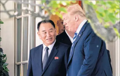  ?? AP PHOTO ?? President Donald Trump talks with Kim Yong Chol, former North Korean military intelligen­ce chief and one of leader Kim Jong Un’s closest aides, as they walk from their meeting in the Oval Office of the White House in Washington Friday.