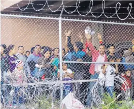  ?? CEDAR ATTANASIO/ASSOCIATED PRESS ?? Central American migrants wait for food in El Paso, Texas, Wednesday in a pen erected by U.S. Customs and Border Protection to process a surge of migrant families