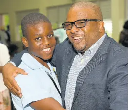  ?? IAN ALLEN/PHOTOGRAPH­ER ?? Twelve-year-old Chrismore Robinson (left) of Knox College in Clarendon receives a congratula­tory hug from his father, Dismore Robinson, after he spelled his way to becoming the Spelling Bee champion for Clarendon on Tuesday.