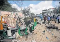  ?? Picture: AFP ?? NIGHT OF TERROR: People walk at the site after an overnight attack at the Pizza House restaurant in Mogadishu