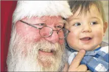  ?? Bruce King as Santa Claus holds Ryan Gilkey at the Kyle Public Library. King plays Santa at the library, companies hire him for gift exchanges, and he’s a regular at senior centers. RALPH BARRERA / AMERICAN-STATESMAN ??