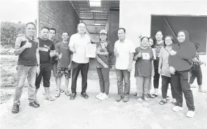  ?? ?? BANTU RAKYAT: Wong (lima kiri) menyerahka­n surat kelulusan pinjaman daripada HDC Sarawak kepada Tuai Rumah Monica di Sibu, semalam.