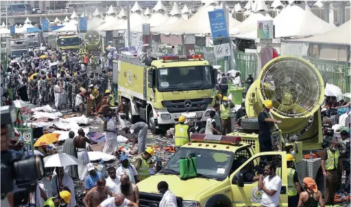  ?? PICTURE: EPA ?? CORRIDOR OF DEATH: Members of the Saudi emergency services move among the bodies of those killed in a stampede as pilgrims look on, in the Mina neighbourh­ood of Mecca yesterday. Saudi officials said that the latest death toll from the stampede, on the...