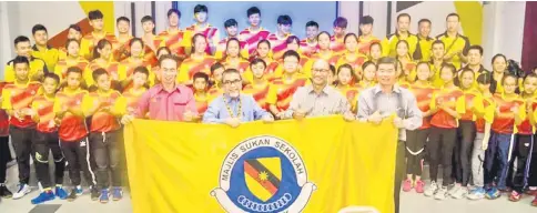  ??  ?? Mat Ali (second left) hands over the MSSS flag to the Sarawak volleyball contingent.