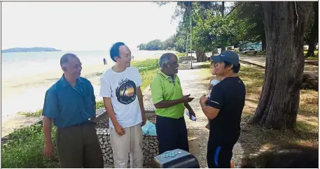  ??  ?? Support us: Muthu (in green) and SOS members speaking to a visitor on the possible reopening of Tanjung Aru beach to the public.