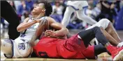  ?? JABLONSKI / STAFF DAVID ?? Rhode Island’s Jeff Downtin, left, and Daytonâ€™s Jalen Crutcher compete for a loose ball on Friday, Feb. 23, 2018, at the Ryan Center in Kingston, R.I. Coaches: Last game: