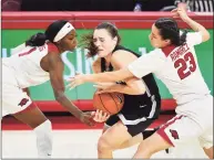  ?? Michael Woods / Associated Press ?? UConn guard Nika Muehl tries to get past Arkansas defenders Marquesha Davis and Amber Ramirez (23) on Thursday.