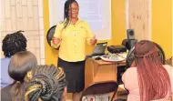  ??  ?? Guardian Life Insurance agent Dillys Lobban (standing) engages students at the Spanish Town Skills Training Centre in St Catherine in a motivation­al talk.