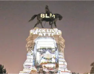  ?? STEVE HELBER/ASSOCIATED PRESS FILE ?? An image of George Floyd is projected on the base of the statue of Confederat­e General Robert E. Lee in Richmond on June 8. The statue has been the focal point of protests over the death of George Floyd. Gov. Ralph Northam has ordered the statue’s removal.