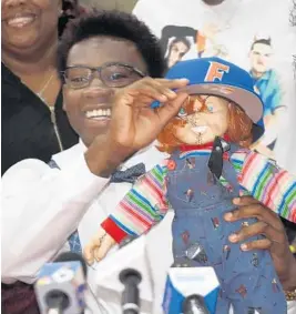  ?? JOE CAVARETTA/SUN SENTINEL ?? Cardinal Gibbons defensive end Khris Bogle indicated his college intention by placing a Florida Gators cap on a Chucky doll. Bogle had been expected to sign with Alabama.