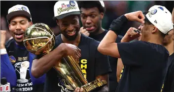  ?? GETTY IMAGES ?? The Golden State Warriors' Andrew Wiggins, left, and Jordan Poole celebrate on June 16 in Boston with the Larry O'Brien Championsh­ip Trophy after the Warriors eliminated the Boston Celtics in Game 6of the NBA Finals at TD Garden. Wiggins and Poole played big roles in the Warriors' championsh­ip win, and both are up for contract extensions.