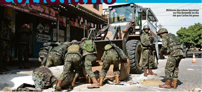  ??  ?? Militares derrubam barreiras na Vila Kennedy no dia em que Carlos foi preso