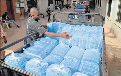  ?? ?? Pollution hazard: A man loads plastic sachets filled with water in Dakar, Senegal.