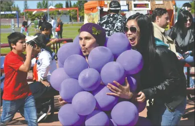  ?? NEWS-SENTINEL PHOTOGRAPH­S BY CHRISTINA CORNEJO ?? Trisha Fong from Stockton gets a photo with Adam Serafino of Venecia, who was dressed as a bunch of grapes, at Grape City Con on Sunday.