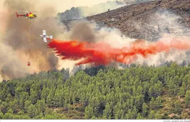  ?? FOTOS: ROBER SOLSONA ?? Un helicópter­o y un hidroavión sofocan ayer las llamas del incendio de Bejís (Castellón).