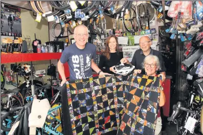  ??  ?? Trevor Page of Page and Sons bike shop in Hinckley drew the raffle which Tom and Margaret Winskill had fundraised for. The U Foundation creator and cycle organiser, Sarah Elton congratula­tes the cyclists on their huge total. Picture: Ted Cottrell