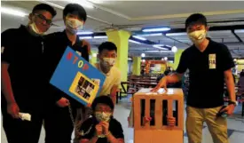  ??  ?? From left: Kenneth Suthan Kee, Ng Weng Tat, Seek Chan Seng (white T-shirt), Darryl Tan Khuan Shung (in chains), Ong Ze Ming (in cage) and Goh Yit Chin raise awareness about human traffickin­g.