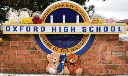  ?? Photos by Scott Olson / Getty Images ?? Stuffed bears and flowers sit at a memorial outside the high school in Oxford, Mich., where police say a 15-year-old opened fire with a newly purchased handgun, killing four students and wounding seven others.