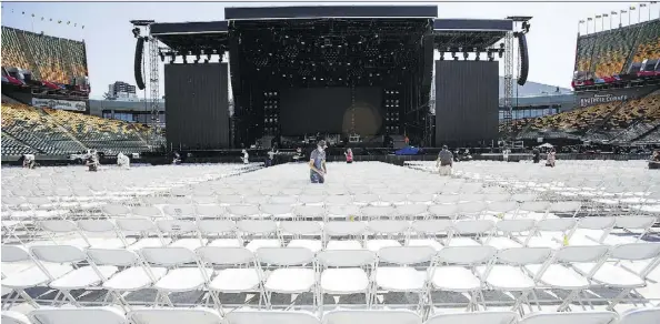  ?? CODIE MCLACHLAN ?? Workers set up floor seats — 8,056 in all — at Commonweal­th Stadium on Tuesday for Wednesday’s Guns N’ Roses show.