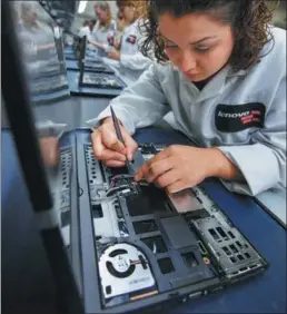  ?? PROVIDED TO CHINA DAILY ?? A Lenovo employee fixes internal cables onto a laptop in Whitsett, the US.