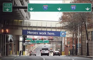  ?? Arnold Gold / Hearst Connecticu­t Media ?? A “Heroes work here” sign hangs on Dec. 4 from the walkway connecting Yale New Haven Hospital to a parking garage in New Haven.
