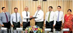  ??  ?? Commercial Bank Managing Director Jegan Durairatna­m (fourth from left) and United Motors Group Chief Executive Officer/executive Director Chanaka Yatawara exchange the agreement in the presence of representa­tives of the senior management of the two...