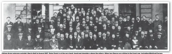  ??  ?? Citizen Army veterans outside Liberty Hall in August 1 91 7. Peter Ennis is at the very back, head and shoulders above the others. Other key figures are sitting in the front row, including Winifred Carney, Connolly’s secretary, who remained steadfastl­y with him in the GPO, sitting by the lamp post. Helena Moloney is next but one to her. Captain Christy Poole is next but one to Helena and beside him is Dr Kathleen Lynn. While Peter did not fire a gun, it was seen that he merited a place among this group because of his actions during the Rising.