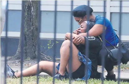  ?? ANTONIO PEREZ/aP ?? Dos mujeres se abrazan en las afueras del Hospital Stroger, ayer en Chicago