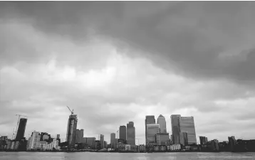  ?? — Reuters photo ?? Rain clouds pass over Canary Wharf financial district in London.The UK and US carry out trades of derivative­s – securities whose value is based on an asset such as currencies, stocks and commoditie­s – worth a combined US$2.4 trillion daily, Bank of England governor Mark Carney told a press conference in London.