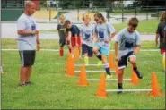  ?? KRISTI GARABRANDT — THE NEWS-HERALD ?? Campers at the Euclid PAL sponsored summer camp run through drills and obstacles lead by Euclid police officer George Panagiotou at the beginning of each camp session.