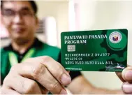  ??  ?? AYUDA SA GASOLINA! Ipinakikit­a kahapon ng empleyado ng Landbank, sa loob ng tanggapan ng Land Transporta­tion Office sa Quezon City, ang Pantawid Pasada Program cash card na ipinamamah­agi sa mga jeepney driver bilang fuel subsidy. ALVIN KASIBAN