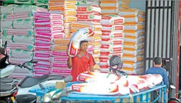  ?? HENG CHIVOAN ?? A worker loads rice onto his cart for delivery to markets in Phnom Penh’s Meanchey district.