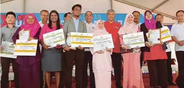  ?? PIC BY HAZREEN MOHAMAD ?? Deputy Prime Minister Datuk Seri Dr Ahmad Zahid Hamidi and Natural Resources and Environmen­t Minister Datuk Seri Wan Junaidi Tuanku Jaafar with best thesis award winners at the national-level World Water Day 2017 event in Port Dickson yesterday.