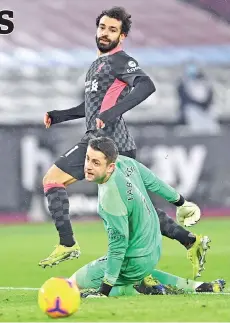  ??  ?? Salah (top) watches as his shot beats West Ham United’s Polish goalkeeper Lukasz Fabianski for their second goal. - AFP photo
