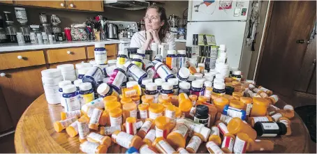 ?? PETER J. THOMPSON ?? Mary Shuttlewor­th displays bottles from medication­s she has taken in the past year to help with pain caused by a car accident she was in six years ago. A judge recently overturned denial of Shuttlewor­th’s insurance coverage and sent the case back for a...