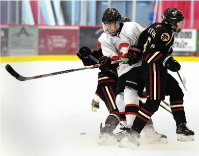  ?? CITIZEN PHOTO BY BRENT BRAATEN ?? Lynden Gaal of the Westwood Panago Cougars gets crunched between two Chilliwack players during the Bon Voyage Inn/Carmel Inn midget Tier 2 tournament, held on the weekend at the Kin Centre.