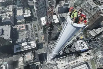  ?? Mel Melcon Los Angeles Times ?? IRONWORKER­S Pete Veliz, left, Vince Parker and Ray Shoats wait inside the spire as the final sections are prepared for attachment atop the skyscraper, which is now the tallest west of the Mississipp­i River.